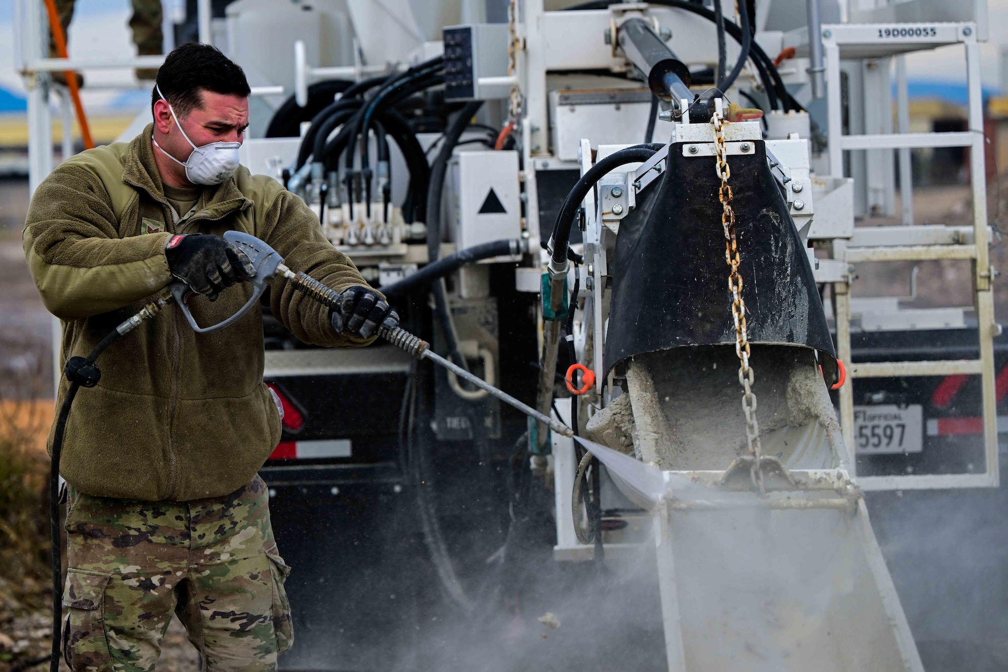 U.S. Air Force Staff Sgt. Paul Vasile, 31st Civil Engineer Squadron pavements and heavy equipment operator, pressure washes concrete mixer.