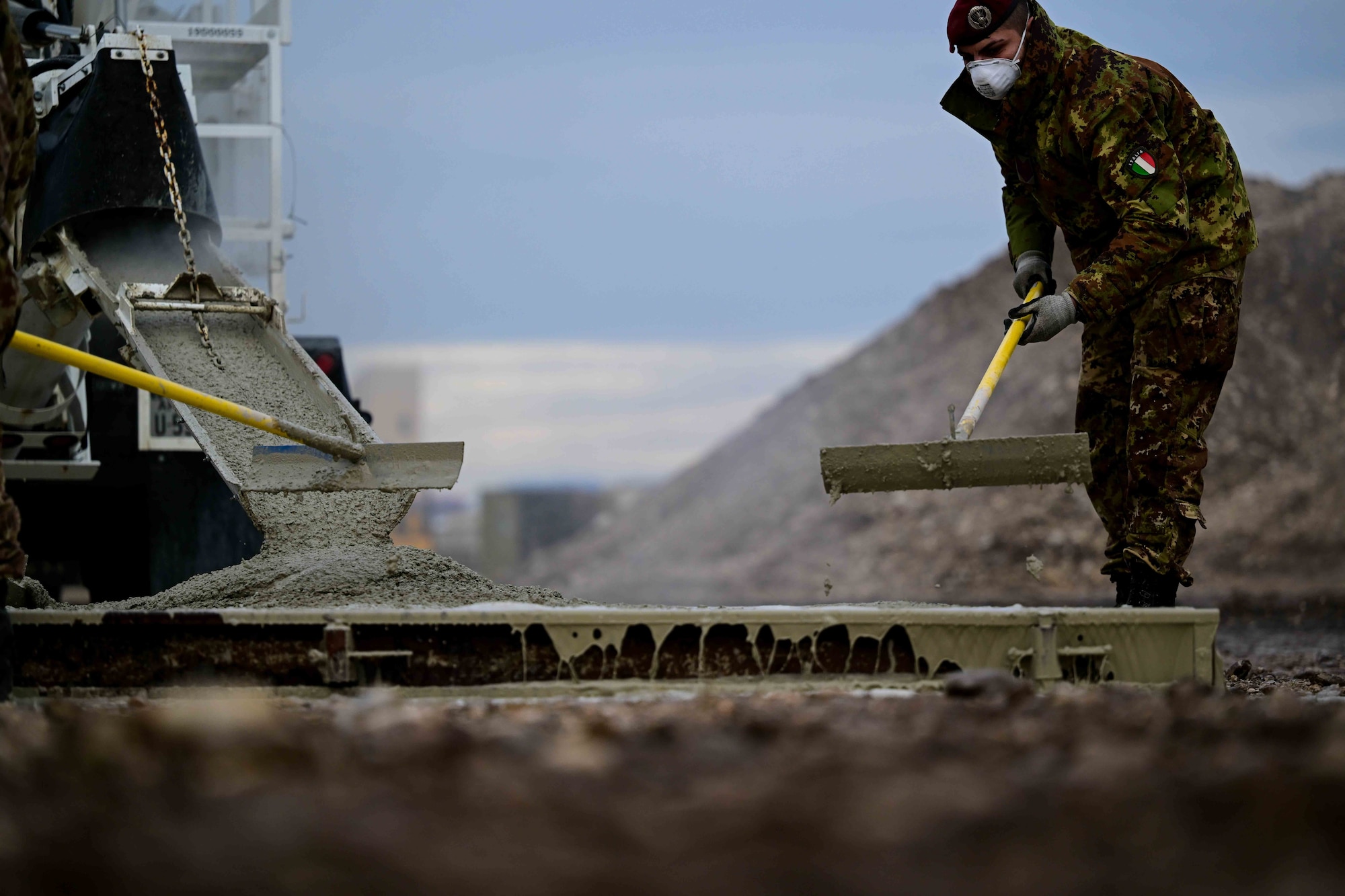 An Italian army solider performs trowel finish during a training exercise.