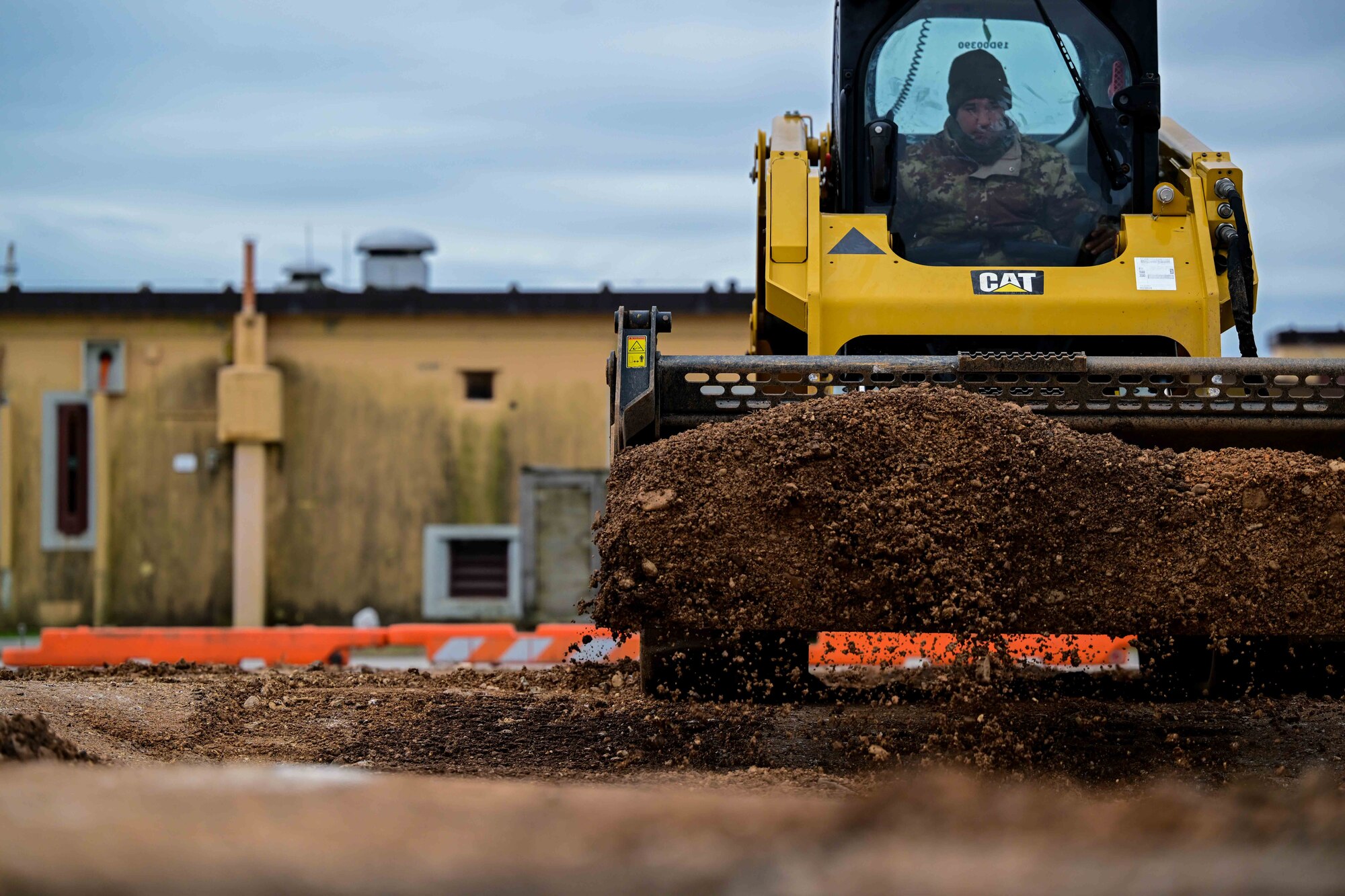 An Italian army solider plows dirt.