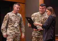 Col. Shawn Nokes, Deputy Chief of Staff for Logistics, Illinois Army National Guard, presents Jade Little, wife of Chief Warrant Officer 4 Ryan Little, with a certificate of appreciation for her support of her spouse’s military service, during a ceremony Dec. 21 at Camp Lincoln, Springfield, Illinois. Little retired after 26 years of service in the Illinois Army National Guard.