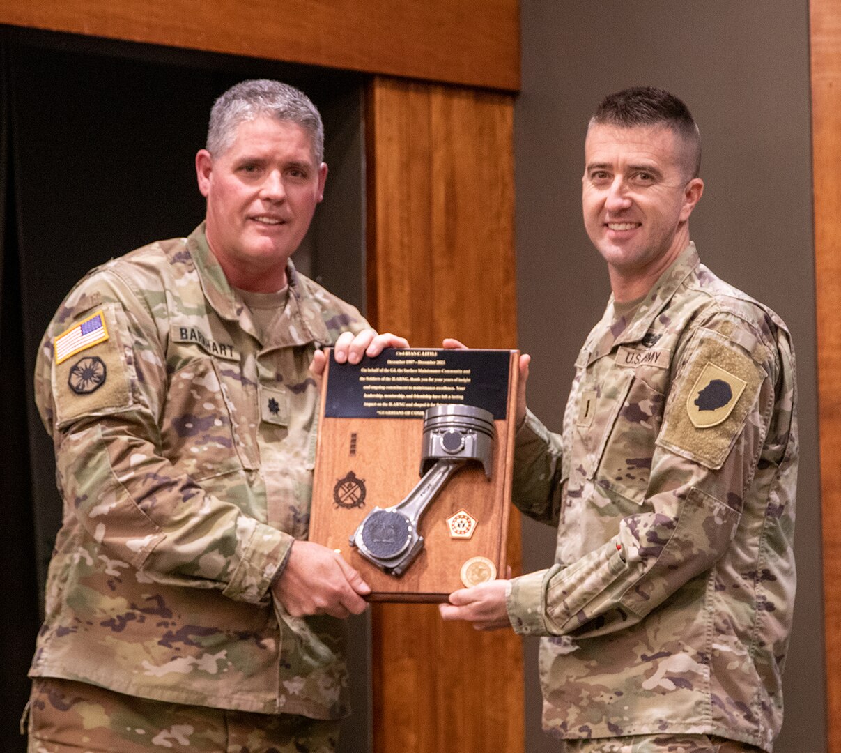 Lt. Col. Timothy Barnhart, Surface Maintenance Manager, Illinois Army National Guard, presents Chief Warrant Officer 4 Ryan Little with a plaque commemorating Little’s career in the ILARNG, during a ceremony Dec. 21 at the Illinois Military Academy, Camp Lincoln, Springfield, Illinois. Little retired after 26 years of service in the Illinois Army National Guard.