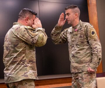 Chief Warrant Officer 4 Ryan Little salutes Col. Shawn Nokes, Deputy Chief of Staff for Logistics, Illinois Army National Guard, after the presentation of the Meritorious Service Medal during a ceremony Dec. 21 at Camp Lincoln, Springfield, Illinois. Little retired after 26 years of service in the Illinois Army National Guard.