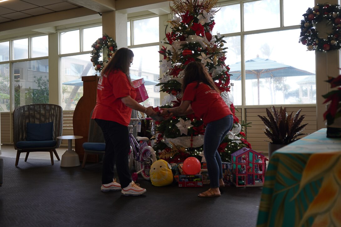 U.S. Army Corps of Engineers first responders aiding with the Hawaii Wildfires combined federal, state, and local response collected more than 70 toys to donate to a Maui toy drive to benefit local children impacted by the disaster. Adrienne Bostic and Cathy Denham place the toys around a Christmas tree at the donation location Dec. 14.