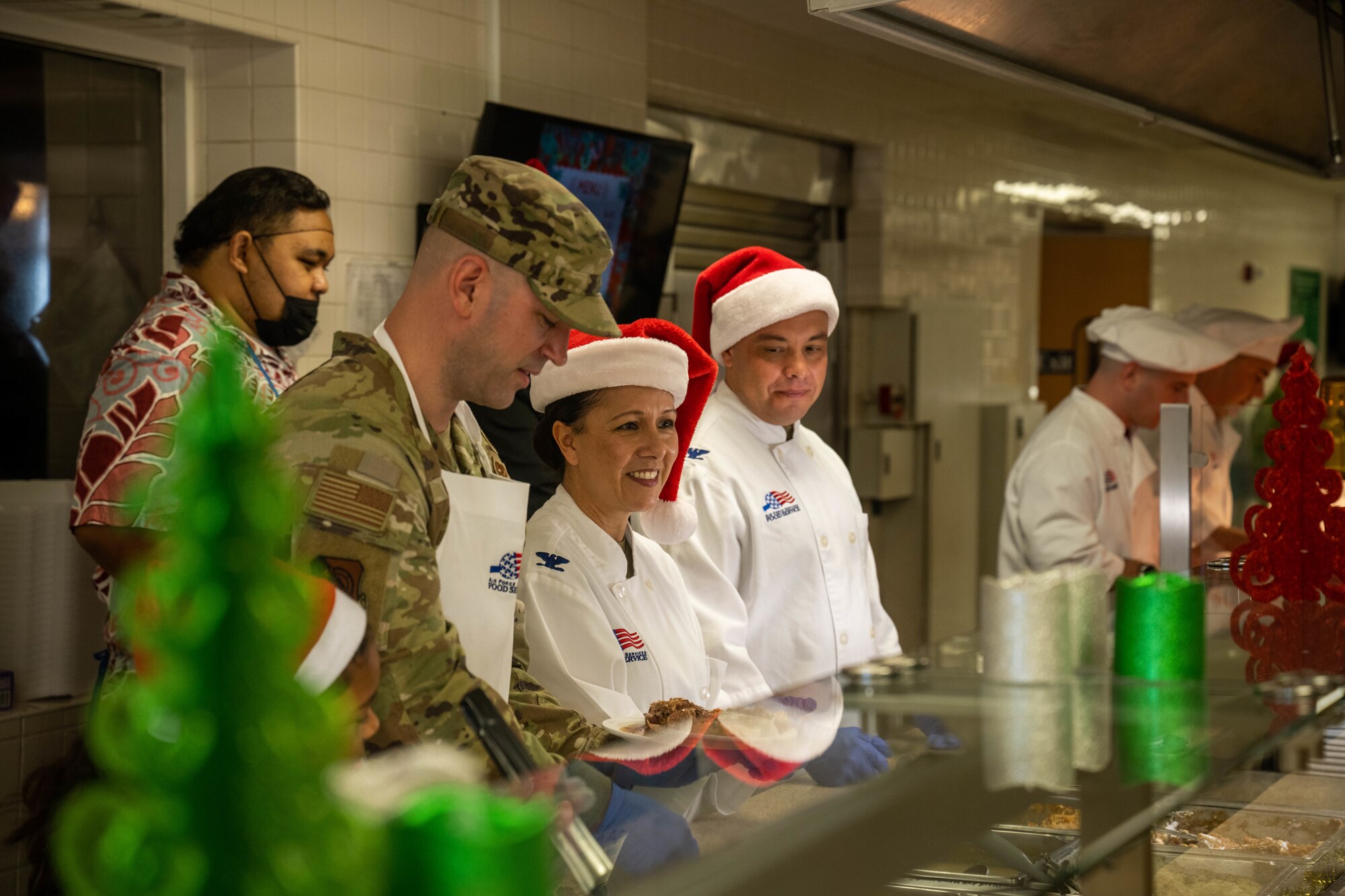 Leadership from the 15th Medical Group serves Christmas Eve lunch to Airmen and families at the Hale Aina Dining Facility on Joint Base Pearl Harbor-Hickam, Hawaii, Dec. 24, 2023. The 647th Force Support Squadron hosted the lunch for several JBPHH personnel and families to ensure those who were not able to travel home during the holiday season still enjoyed a holiday meal. (U.S. Air Force photo by Senior Airman Makensie Cooper)