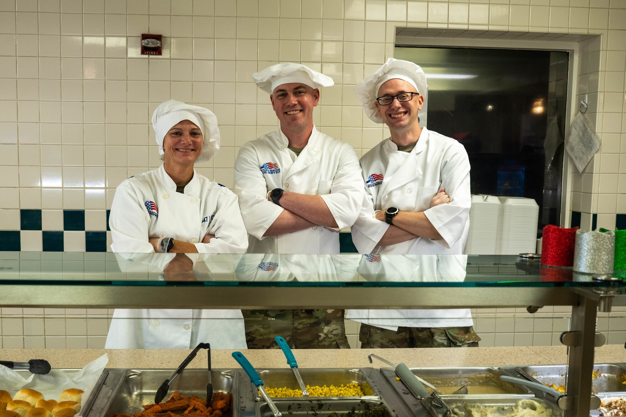 Volunteers pose for a photo while serving Christmas Eve lunch at the Hale Aina Dining Facility on Joint Base Pearl Harbor-Hickam, Hawaii, Dec. 24, 2023. Leaders from the 15th Wing, 515th Air Mobility Wing and 647th Air Base Group attended the event to serve Airmen and their families lunch on Christmas Eve. (U.S. Air Force photo by Senior Airman Makensie Cooper)