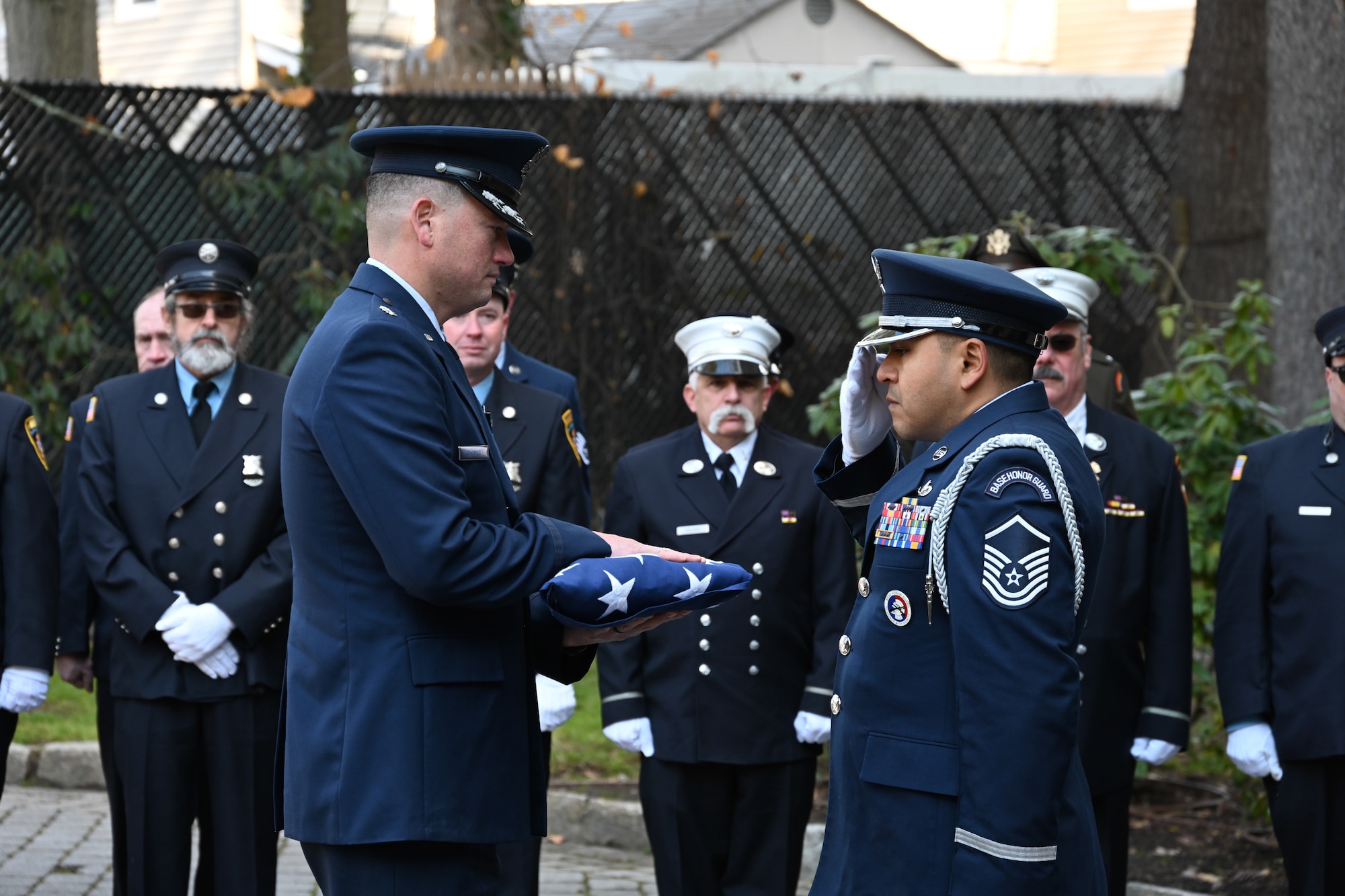 New York Air National Guard Master Sgt. Edison Aguilar, the 105th Airlift Wing honor guard program manager, salutes a memorial flag after presenting it to U.S. Air Force Lt. Col. Benjamin Thomas, the commander of the 105th Civil Engineer Squadron, during a memorial service for former Air Guard Tech. Sgt. Mario Scaduto in Yonkers, New York, Dec. 16, 2023. This was one of 1,990 military funerals New York Air Guard honor guards expected to provide in 2023.