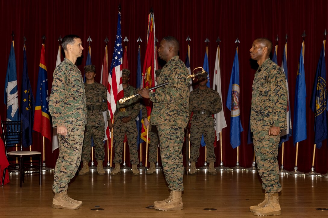 U.S. Marine Corps Sgt. Maj. Reginald Daniels, outgoing sergeant major of I Marine Expeditionary Force Information Group, passes the noncommissioned officer sword to Col. William Osborne, the commanding officer of I MIG, during the I MIG Relief and Appointment Ceremony on Marine Corps Base Camp Pendleton, California, Dec. 22, 2023. The Relief and Appointment Ceremony represents the official passing of responsibilities from one senior enlisted leader to another. (U.S. Marine Corps photo by Sgt. Samuel C. Fletcher)