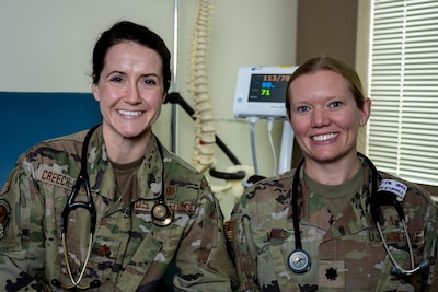 U.S. Air Force Maj. Julie Creech-Organ, 375th Healthcare Operations Squadron director of osteopathic education, and Lt. Col. Pamela Hughes, 375th HOS military programs director, pose for a picture at Scott Air Force Base, Illinois, Dec. 21, 2023. Creech-Organ and Hughes, through a collaborative effort with St. Louis University, St. Elizabeth’s, and SIHF Healthcare, are transforming the way osteopathic medical residents receive training with a new 3-year family medicine residency program for doctors of osteopathic medicine at Scott. (U.S. Air Force photo by Senior Airman Violette Hosack)