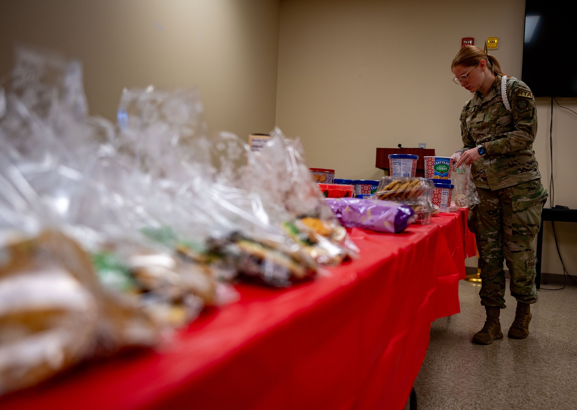 U.S. Air Force Airman 1st Class Alyssa Kusmich, 436th Aerial Port Squadron  ramp training monitor, bags cookies for Operation Cookie Drop at the chapel on Dover Air Force Base, Delaware, Dec. 18, 2023. Kusmich volunteered with the Dover AFB Chapel and USO of Delaware to deliver more than 3,000 cookies to Airmen across the base. (U.S. Air Force photo by Airman 1st Class Amanda Jett)