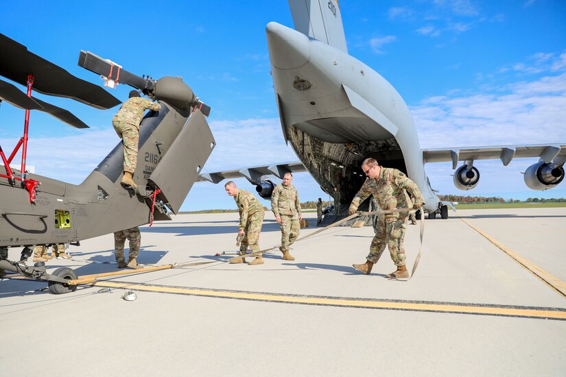 Approximately 25 U.S. Soldiers and Airmen with the Pennsylvania National Guard work together Oct. 13 to load a UH-60M Blackhawk helicopter onto a C-17 cargo aircraft and transport it from Army Aviation Support Facility in Johnstown, Pa., to Pittsburgh and back. This training prepares the Guardsmen to efficiently fold the helicopter, load it into a cargo aircraft, and transport it in support of domestic operations or overseas deployment. (U.S. Army National Guard photo by Sgt. 1st Class Zane Craig)