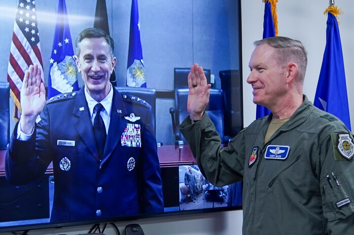 U.S. Air Force Lt. Gen. Kevin Schneider, left, director of staff, Headquarters Air Force, administers the reaffirmation of oath over a video call to Maj. Gen. Curtis Bass, deputy commander, U.S. Air Force Warfare Center, at Nellis Air Force Base, Nevada, Dec. 9, 2023.