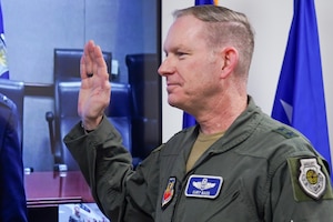 U.S. Air Force Maj. Gen. Curtis Bass, deputy commander, U.S. Air Force Warfare Center, raises his right hand while reciting the oath of office at Nellis Air Force Base, Nevada, Dec. 9, 2023.