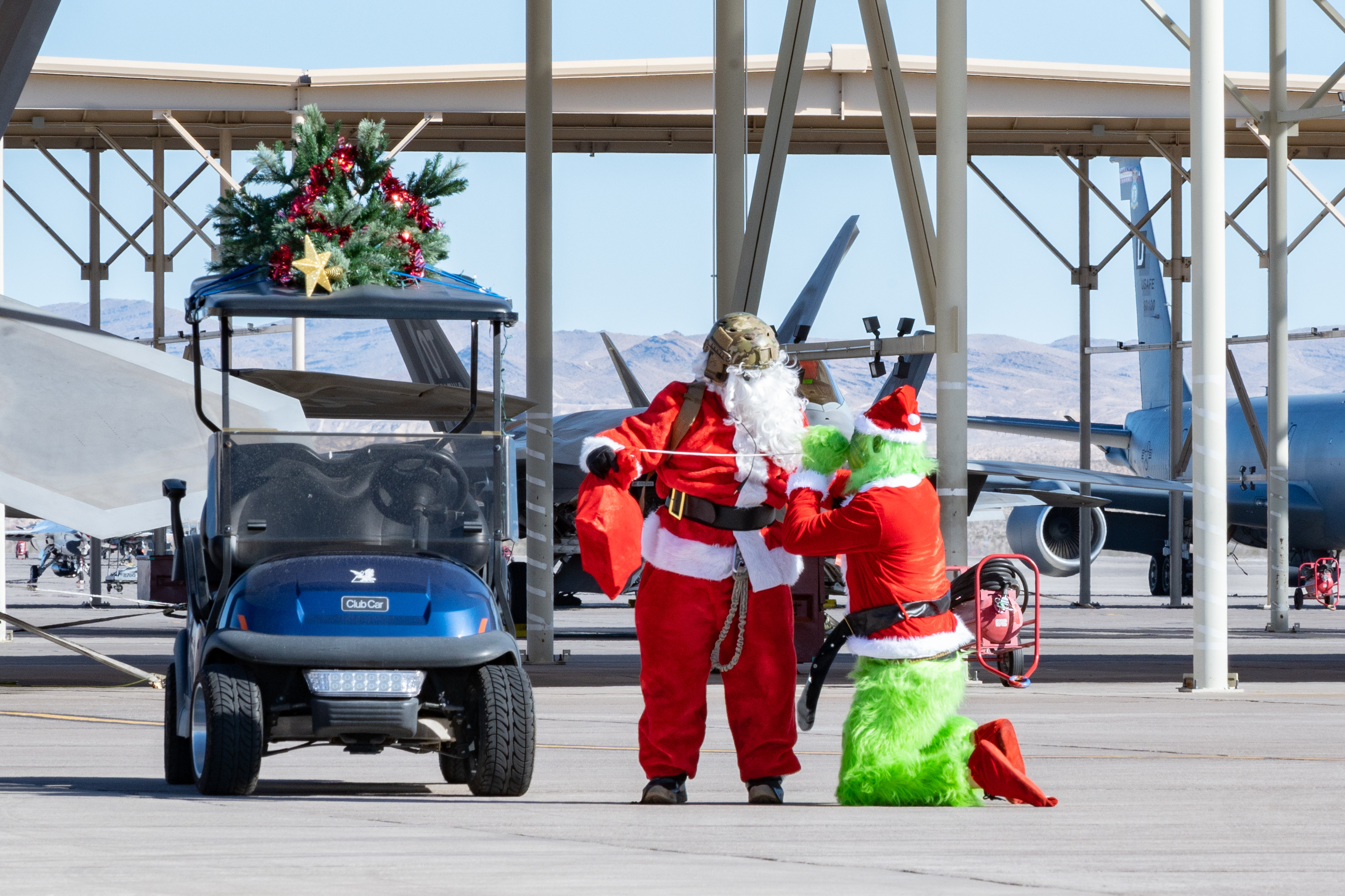 U.S. Air Force Chief Master Sgt. Jared Pietras, Senior Enlisted leader of the United States Air Force Weapons School (USAFWS), dresses up as Santa Clause and reprimands Lt. Col. Adam Clift, the Grinch, for trying to steal the sack of presents at Nellis Air Force Base, Nevada, Dec. 9, 2023. This performance was dedicated to USAFWS Airmen and their families for a holiday party and to build morale. (U.S. Air Force photo by Airman 1st Class Elizabeth Tan)