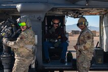 Two Airmen from the 88th Test and Evaluation Squadron and Thomas McGrath, middle, vice president of the Air Force Association Thunderbird Chapter and president of the National Marine Corps Business Network, prepare for a civic leader flight at Nellis Air Force Base, Nevada, Dec. 12, 2023.