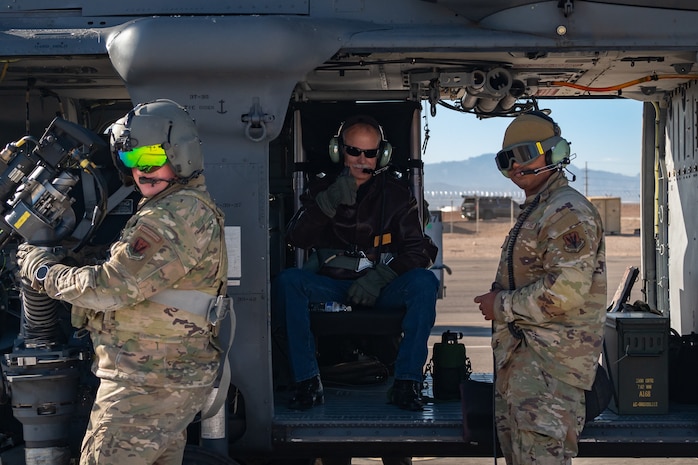 Two Airmen from the 88th Test and Evaluation Squadron and Thomas McGrath, middle, vice president of the Air Force Association Thunderbird Chapter and president of the National Marine Corps Business Network, prepare for a civic leader flight at Nellis Air Force Base, Nevada, Dec. 12, 2023.