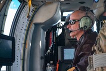 Thomas McGrath, vice president of the Air Force Association Thunderbird Chapter and president of the National Marine Corps Business Network, prepares to fire a .50 caliber machine gun on the HH-60W Jolly Green II as part of the 53rd Wing Civic Leader flight at the Nevada Test and Training Range, Nevada, Dec. 12, 2023.