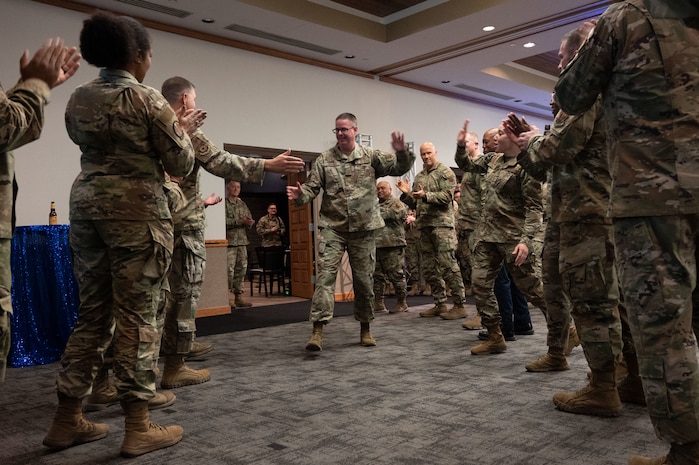 U.S. Air Force Senior Master Sgt. Mitchell Higgins, a superintendent assigned to 757th Aircraft Maintenance Squadron gives high fives while walking into the ballroom prior to the celebration of his upcoming promotion to Chief Master Sgt. at the select party in the Nellis Club at Nellis Air Force Base, Nevada, Dec. 7, 2023.