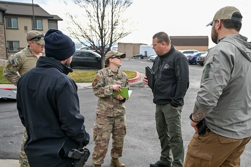 Technical Sgt. Jessica Johnson, 775th Explosive Ordnance Disposal Flight, discusses the scenario with Lt. John Gulley, Davis County Bomb Squad commander, during a training exercise Dec. 20