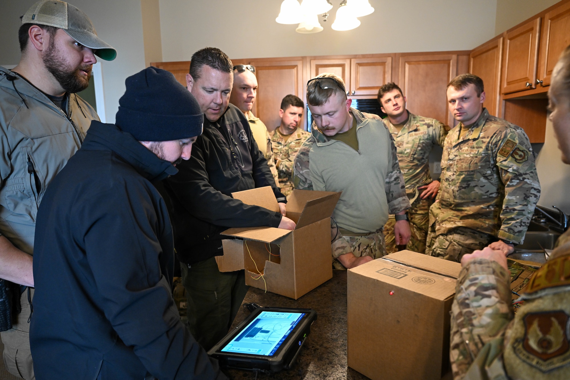 Technicians from the 775th Explosive Ordnance Disposal Flight and the Davis County Bomb Squad discuss tactics used to disable a simulated explosive device during a training exercise
