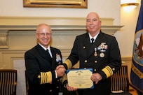Adm. Daryl Caudle, commander, U.S. Fleet Forces Command, left, presents Vice Adm. William Houston, right, with the Distinguished Service Medal during the Commander, Submarine Forces change of command ceremony onboard Naval Station Norfolk, Dec. 28.