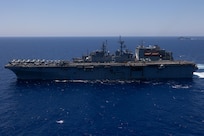 MEDITERRANEAN SEA (Aug. 4, 2023) A MH-60S Sea hawk helicopter, assigned to Helicopter Sea Combat Squadron (HSC) 26, transfers cargo onto the flight deck of the Wasp-class amphibious assault ship USS Bataan (LHD 5) during a replenishment-at-sea. Bataan, along with the Harpers Ferry-class dock landing ship USS Carter Hall (LSD 50) are currently on a scheduled deployment to the U.S. 5th and U.S. 6th Fleet areas of responsibility. The U.S. Navy and U.S. Marine Corps routinely participate in scheduled deployments to improve combined combat readiness, increase operational capacity, and strengthen relationships among allies and partners throughout the region. (U.S. Navy photo by Mass Communication Specialist 3rd Class Alisha Gleason)