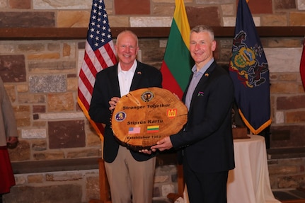 Maj. Gen. Mark Schindler, Adjutant General of Pennsylvania, left, and Lt. Gen. Valdemaras Rupšys Chief of Defense of the Republic of Lithuania hold a gift which recognizes the 30-year military-to-military partnership between the Lithuanian Armed Forces and PA National Guard. The gift combines part of an Oak tree, the national tree of Lithuania, and part of an Eastern Hemlock, the Pennsylvania state tree.