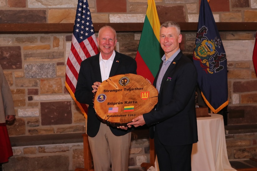 Maj. Gen. Mark Schindler, Adjutant General of Pennsylvania, left, and Lt. Gen. Valdemaras Rupšys Chief of Defense of the Republic of Lithuania hold a gift which recognizes the 30-year military-to-military partnership between the Lithuanian Armed Forces and PA National Guard. The gift combines part of an Oak tree, the national tree of Lithuania, and part of an Eastern Hemlock, the Pennsylvania state tree.