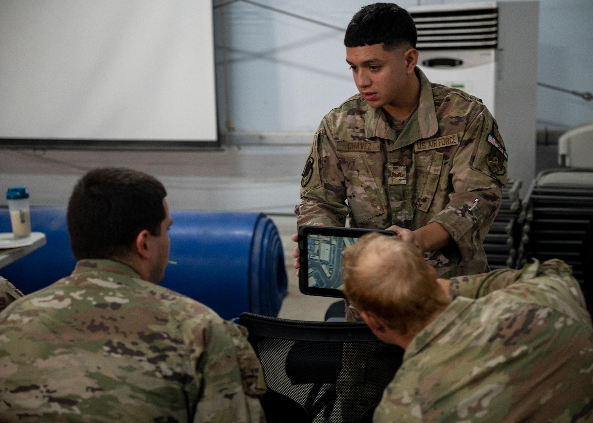 U.S. Air Force Senior Airman Isaac Chavez, security forces squadron defender, trains security forces Airmen on the Android Tactical Assault Kit (ATAK) system at an undisclosed location within the U.S. Central Command area of responsibility, Dec. 16, 2023. The system was introduced to defenders deployed during the first-ever Air Force Force Generation deployment.  (U.S. Air Force photo by Tech. Sgt. Sergio A. Gamboa)