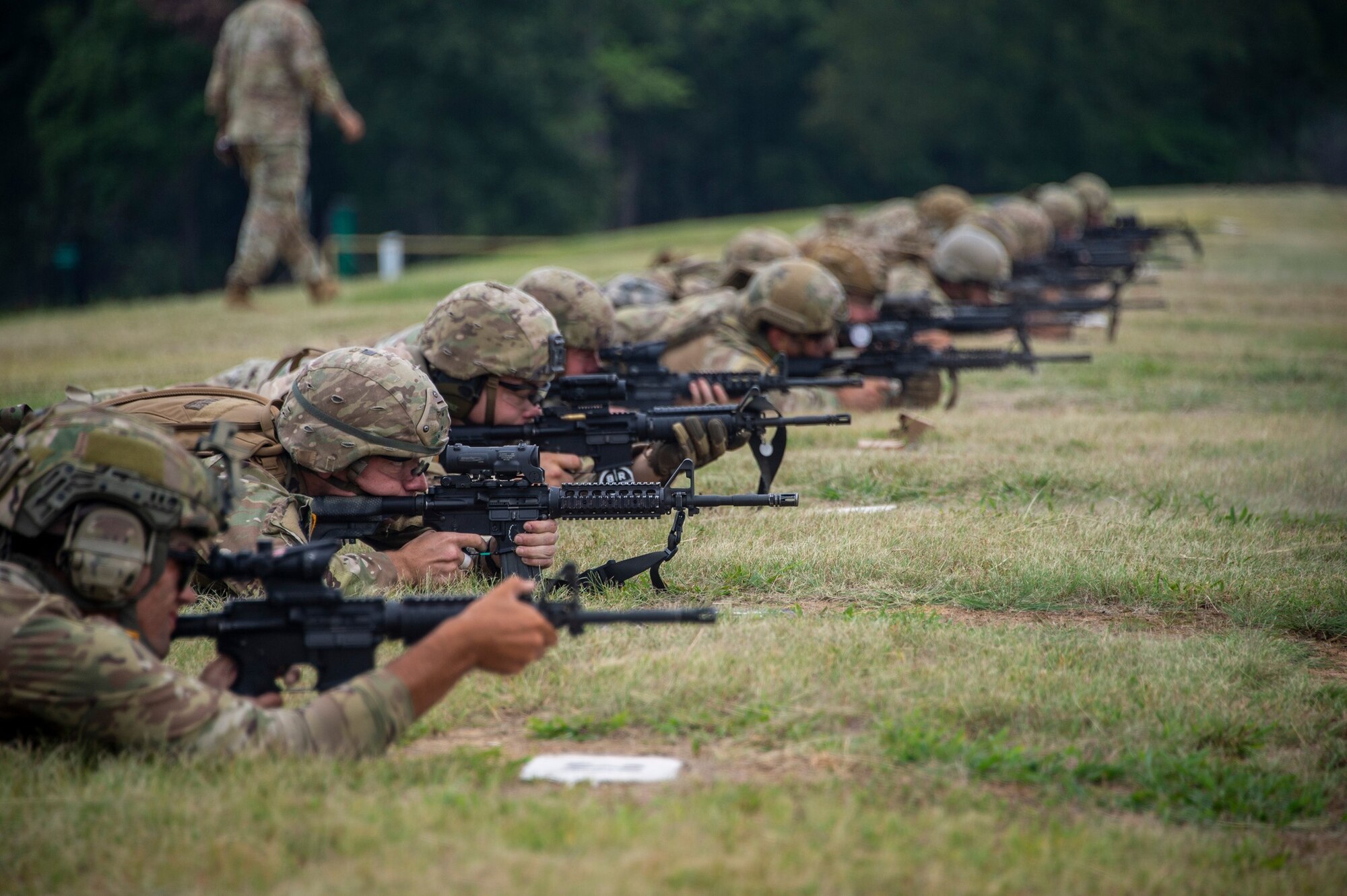U.S. Soldiers and Airmen lay prone on a rifle range preparing to fire.
