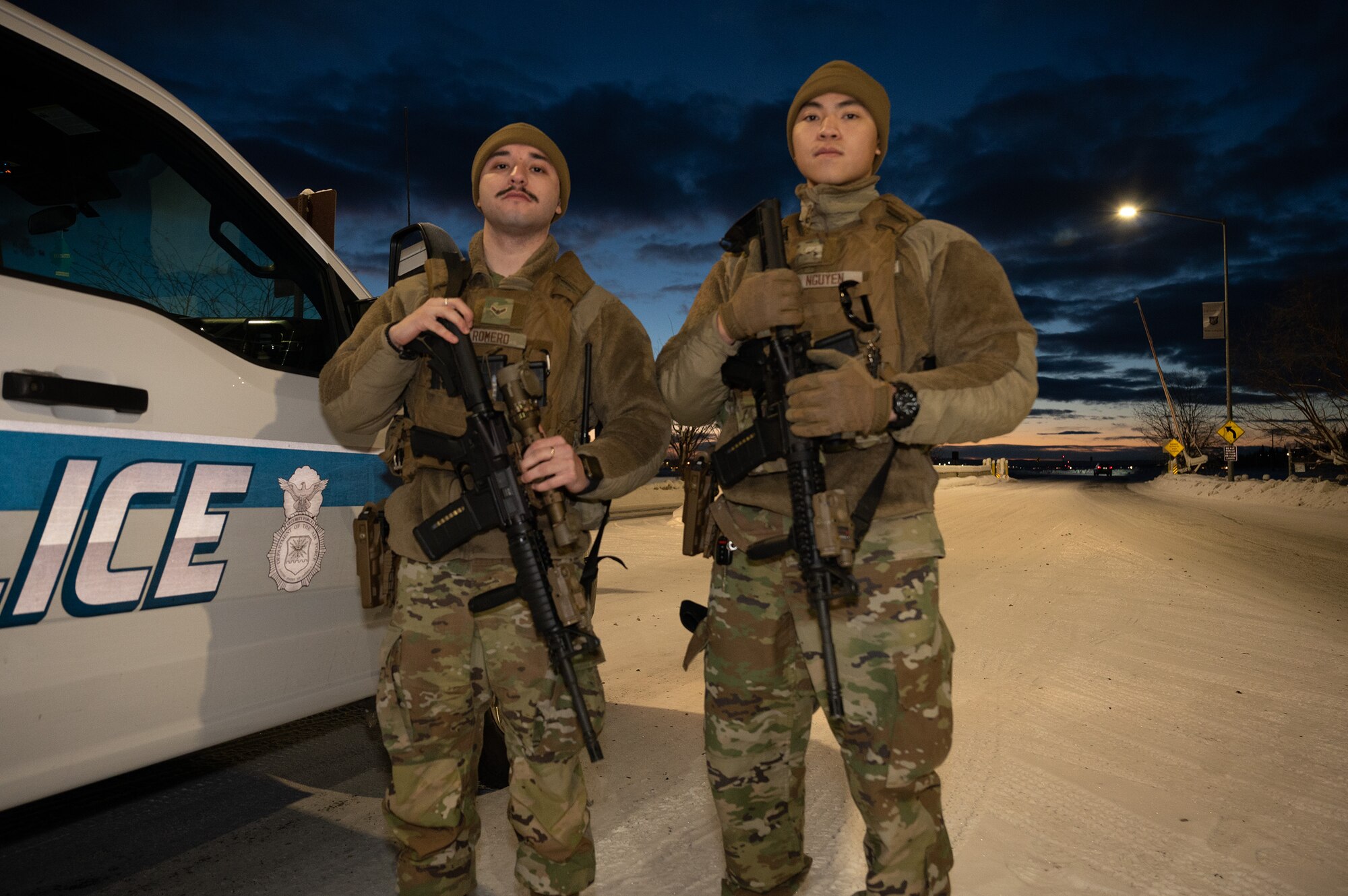 U.S. Air Force Airman 1st Class Leonardo Romero (left) and Airman Albert Nguyen (right), 354th Security Forces Squadron installation entry controllers, stand guard at the main gate on Eielson Air Force Base, Alaska, Dec. 27, 2023.The 354th SFS provides law enforcement and security services while safeguarding the base and transient aircraft. (U.S. Air Force photo by Airman Spencer Hanson)