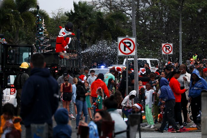 Families gather to watch the Santa Parade, Marine Corps Base Hawaii, Dec. 19, 2023. The parade, which consisted of volunteers from PMO, United Service Organizations, Aircraft Recue and Firefighting, Explosive Ordnance Disposal, Federal Fire Department, Base Safety Department and other organizations, made several stops across the installation to pass out candy and spread holiday cheer. (U.S. Marine Corps photo by Lance Cpl. Hunter Jones)