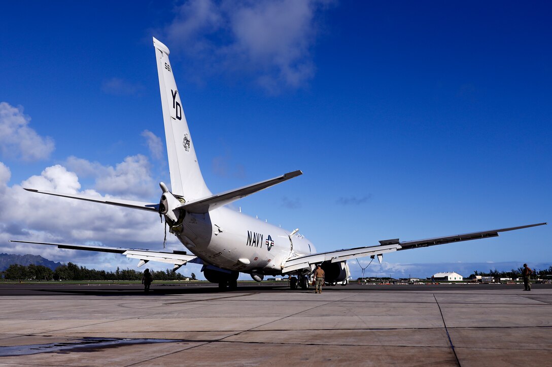 U.S. Navy Sailors tow a U.S. Navy P-8A Poseidon to a designated wash area after extraction from waters just off the runway at Marine Corps Air Station Kaneohe Bay, Marine Corps Base Hawaii, Dec. 4, 2023. The aircraft was relocated in preparation for decontamination of any potential foreign substances as well as salt water from its exterior. U.S. Navy Sailors and Marines worked with local and off-island specialists to recover the structurally intact P-8A Poseidon on Dec. 2, 2023; environmental protection measures were set in place, including 24/7 monitoring, containment booms, absorbent material, and a skimmer on standby during extraction. (U.S. Marine Corps photo by Lance Cpl. Hunter Jones)