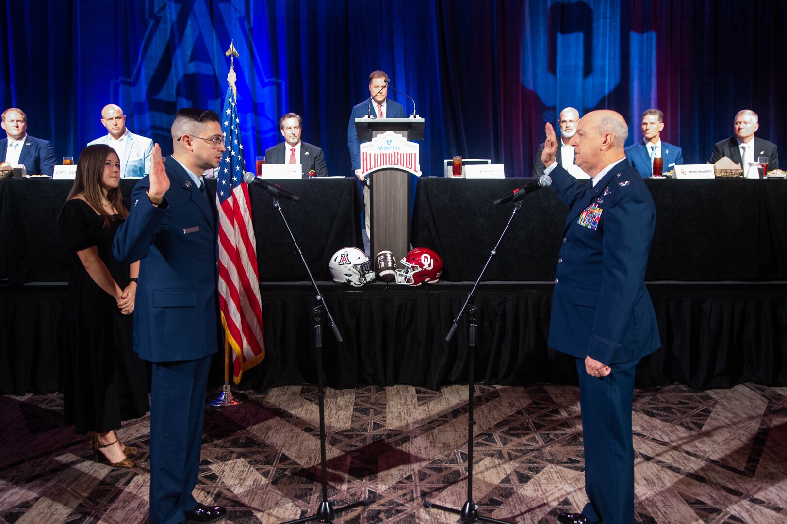 Tech. Sgt. Sean Harbin, 433rd Logistics Readiness Squadron logistics planner, swears in at a reenlistment ceremony at the Valero Alamo Bowl in Downtown San Antonio. The reenlistment is officiated by Col. James Miller, 433rd Operations Group commander.