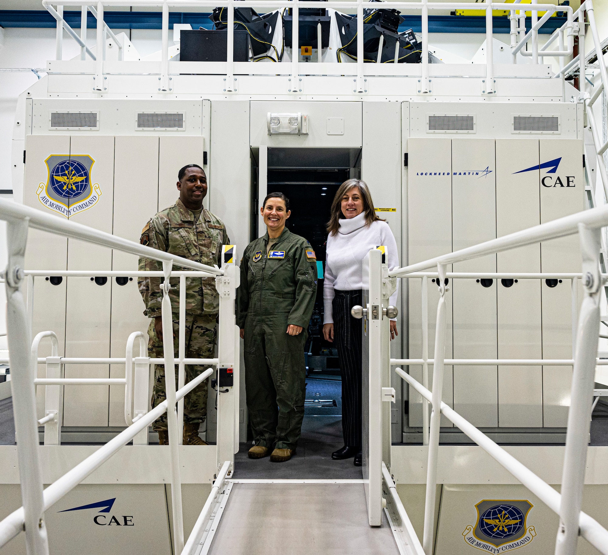 U.S. Air Force Lt. Col. Taylor Rigollet, 86th Operations Support Squadron commander stands with her team in front of an aircraft simulator at Ramstein Air Base, Germany, Jan. 31, 2023. The simulator is designed to train aircrew members how to operate a C-130J Hercules aircraft while minimizing the risks of operating an actual aircraft. (U.S. Air Force photo by Senior Airman Thomas Karol)