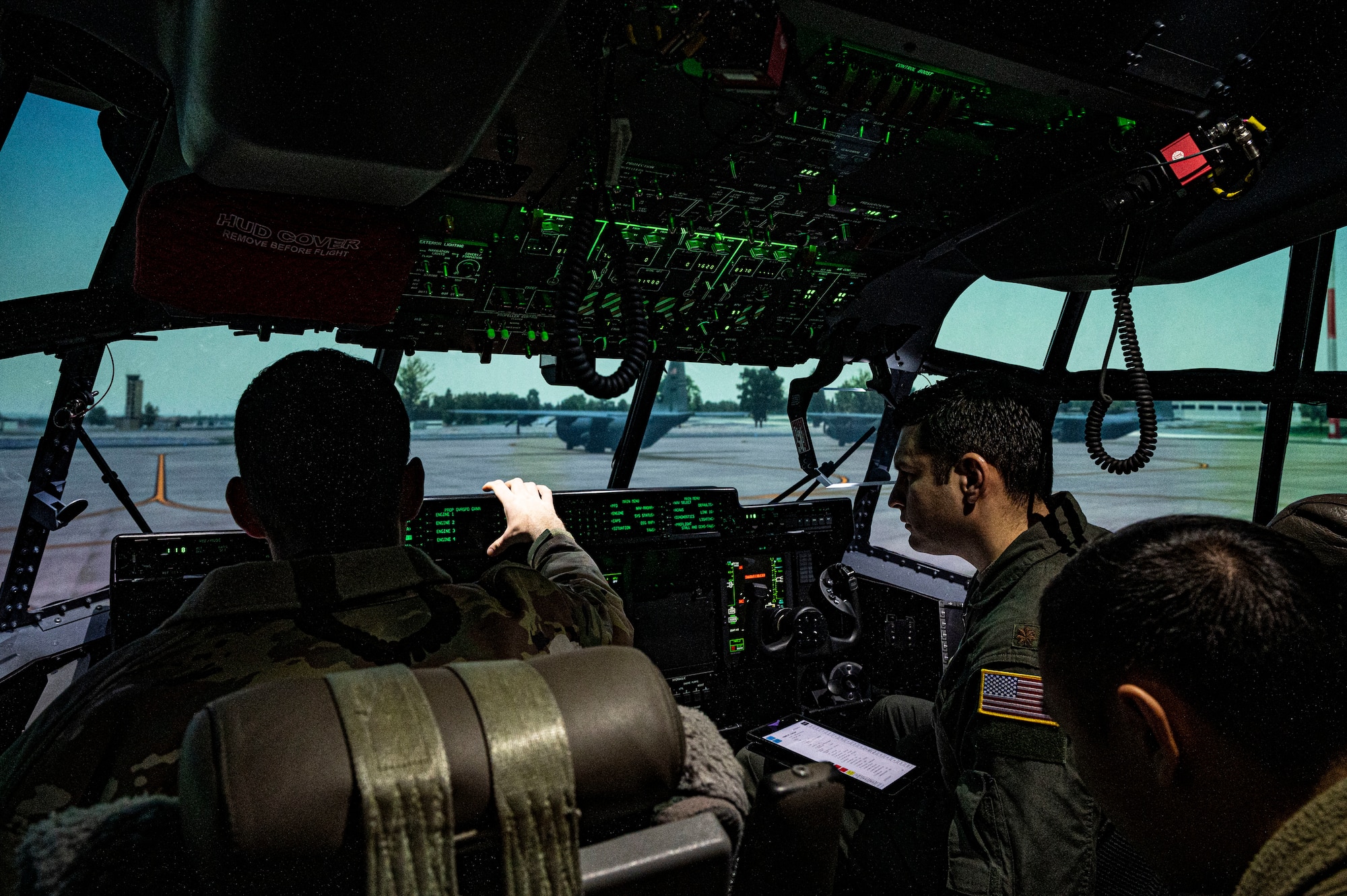 Two pilots from the 37th Airlift Squadron set up the controls for a C-130J Super Hercules aircraft simulator at Ramstein Air Base, Germany, Feb. 1, 2023. Pilots regularly train on the aircraft simulator instead of traveling to other locations to train, which saves Ramstein approximately $350,000 a year. (U.S. Air Force photo by Senior Airman Thomas Karol)