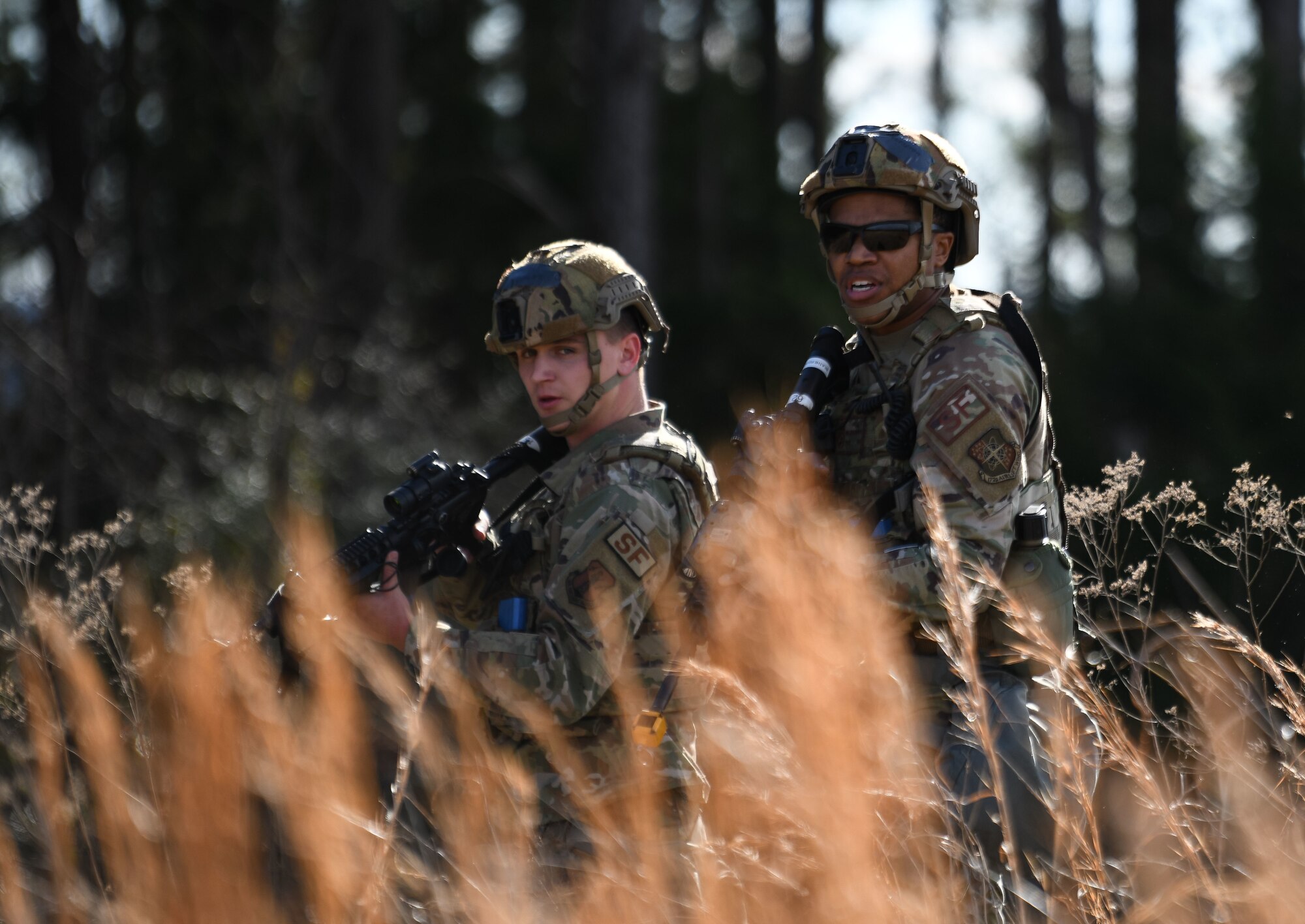 Two Airmen assigned to the 172nd Security Forces Squadron survey a training field during a simulated base attack in Jackson, Mississippi on Jan. 29, 2023. The large-scale readiness exercise tested the Wing’s ability to operate in a deployed environment under various levels of threats. (U.S. Air National Guard photo by Airman 1st Class Shardae McAfee)