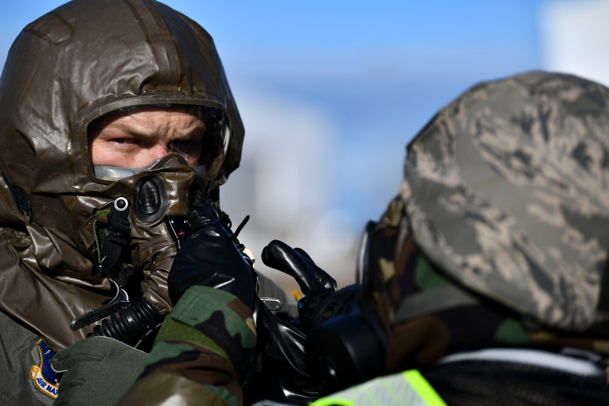 Capt. Justin Hill, a pilot assigned to the 183rd Airlift Squadron, receives an aircrew eye and respiratory protection system check as he goes through a simulated decontamination line during a large-scale readiness exercise in Jackson, Mississippi, Jan. 28, 2022. The AERPS equipment consists of a rubber mask, multiple layers of boots and gloves, fan filter system and an audio and speaker system, which is uniquely designed for aircrew members working in contaminated environments. (U.S. Air National Guard photo by 1st Lt. Kiara Spann)