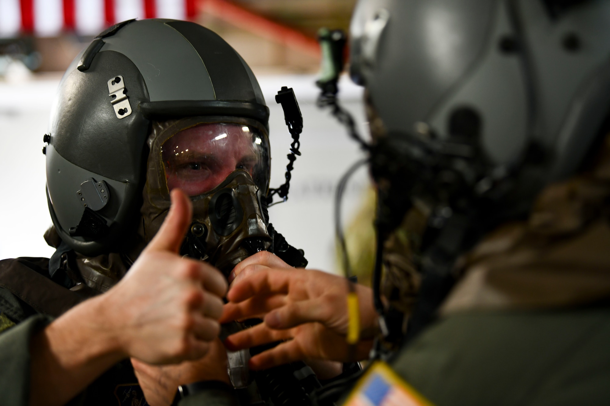 Master Sgt. Mitchell Baker, a loadmaster assigned to the 183rd Airlift Squadron, receives a buddy check as he dons his aircrew eye and respiratory protection system during a large-scale readiness exercise in Jackson, Mississippi, Jan. 28, 2022. The 172nd Airlift Wing conducted a base-wide LRE to test the unit's ability to operate in a contested environment. (U.S. Air National Guard photo by 1st Lt. Kiara Spann)