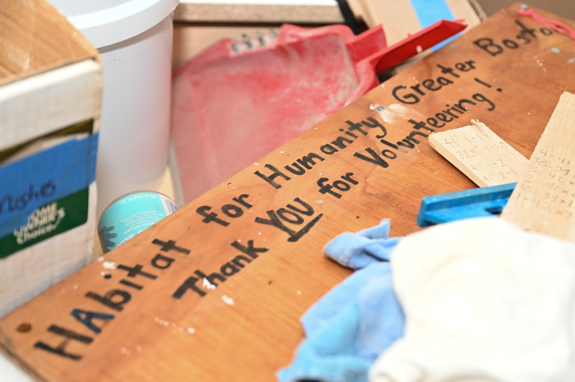 A sign thanking volunteers sits among items at a Habitat for Humanity house building project in Boston, Mass., Jan. 13. Members of the Hanscom Air Force Base, Mass., Company Grade Officers Council volunteered their time to help build a new duplex home as a way to give back to the community. (U.S. Air Force photo by Mark Herlihy)