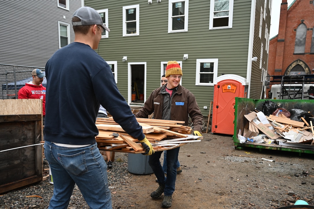 Capt. Adam Johnson and Capt. Caleb Cloud, Hanscom Air Force Base, Mass., Company Grade Officer Council volunteers, move debris on a construction site during a habitat for Humanity home building project in Boston, Mass., Jan. 13. Members of the Hanscom CGOC volunteered their time to help build a new duplex home as a way to give back to the community.  (U.S. Air Force photo by Mark Herlihy)