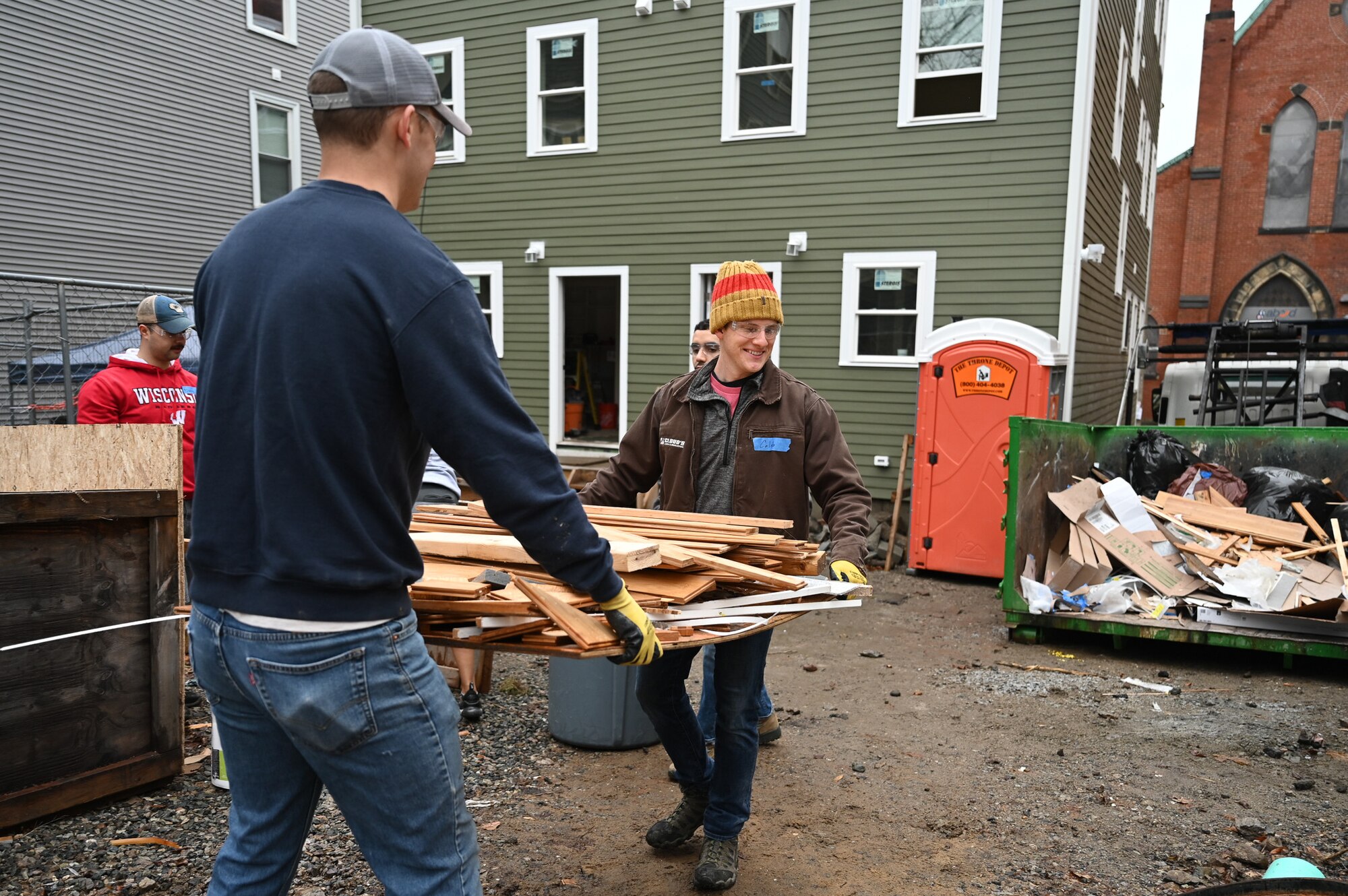 Capt. Adam Johnson and Capt. Caleb Cloud, Hanscom Air Force Base, Mass., Company Grade Officer Council volunteers, move debris on a construction site during a habitat for Humanity home building project in Boston, Mass., Jan. 13. Members of the Hanscom CGOC volunteered their time to help build a new duplex home as a way to give back to the community.  (U.S. Air Force photo by Mark Herlihy)