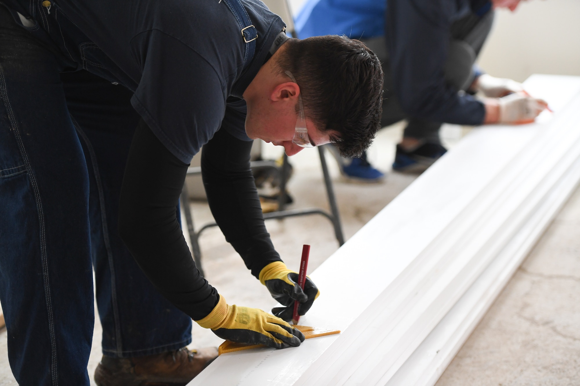 1st Lt. Alex Urban, E-3 Modernization Branch program manager,  Hanscom Air Force Base, Mass., measures a piece of wood at a Habitat for Humanity home building project in Boston, Mass., Jan. 13. Hanscom Company Grade Officers Council members volunteered their time to help build a new duplex home as a way to give back to the community. (U.S. Air Force photo by Mark Herlihy)