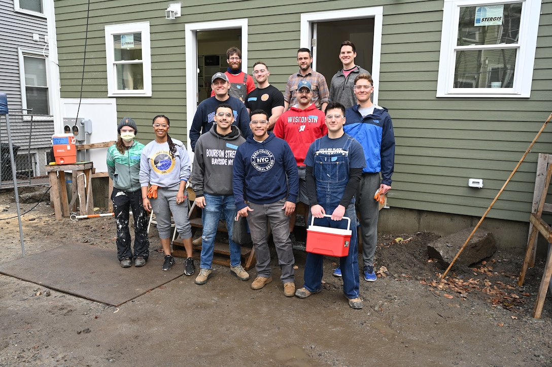 Members of the Hanscom Air Force Base, Mass., Company Grade Officers Council pose for a photo with Habitat for Humanity site supervisors during a home building project in Boston, Mass., January 13. Hanscom CGOC members volunteered their time to help build a new duplex home as a way to give back to the community. (U.S. Air Force photo by Mark Herlihy)