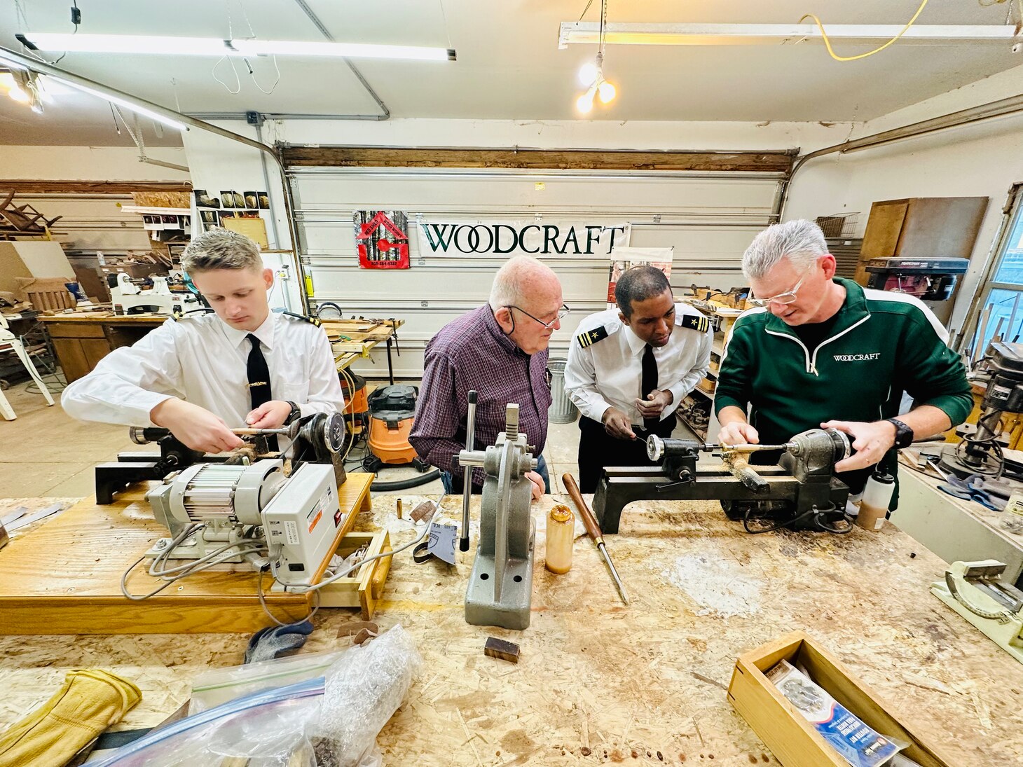 Lt. Cmdr. Darrell Smith, left center, executive officer of the future USS Idaho (SSN 799), and Lt. Beckett Lemley, left, the ship’s navigator, create pens with local woodworkers in Boise, Idaho, Jan. 24.