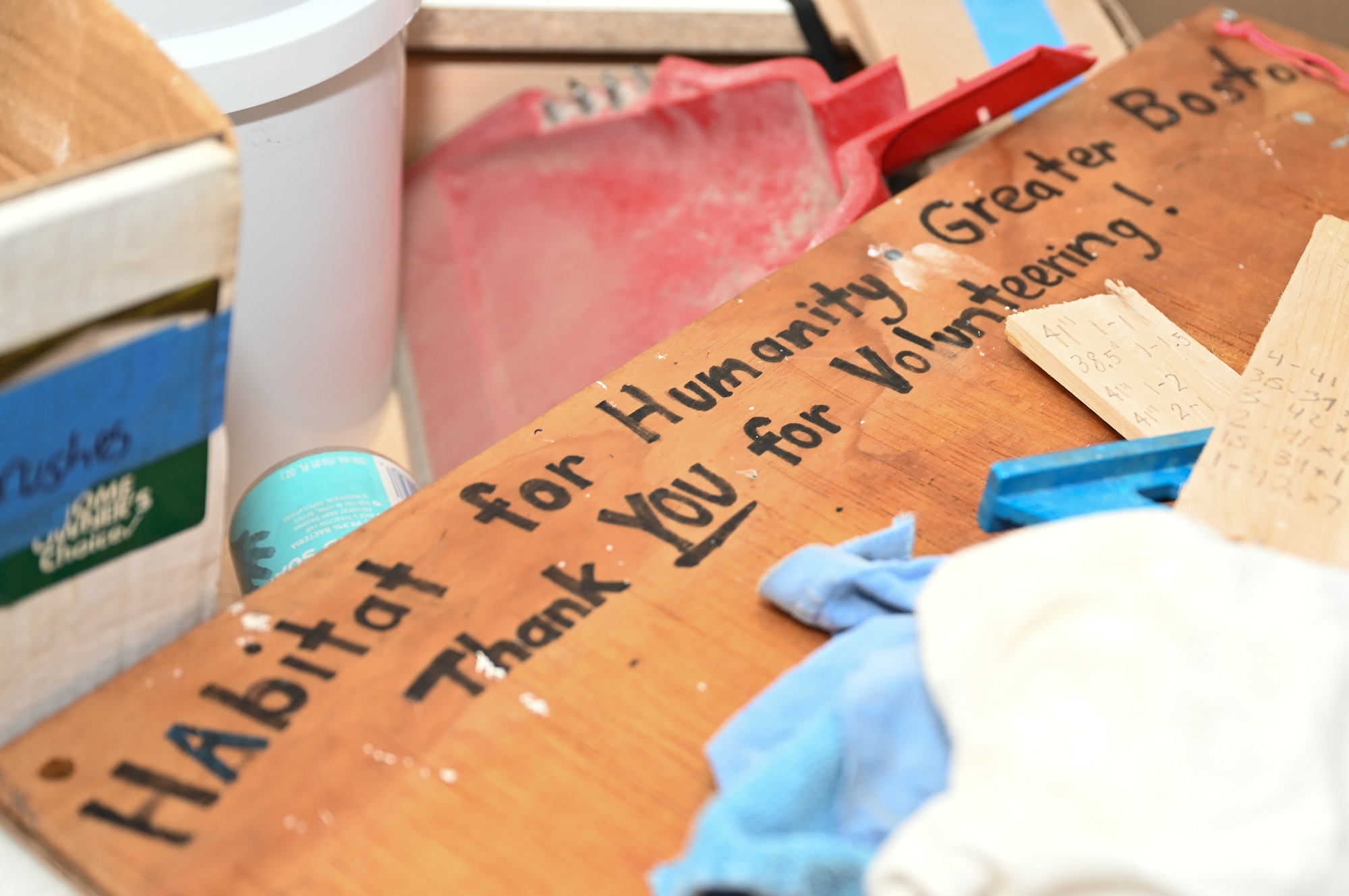 A sign thanking volunteers sits among items at a Habitat for Humanity house building project in Boston, Mass., Jan. 13. Members of the Hanscom Air Force Base, Mass., Company Grade Officers Council volunteered their time to help build a new duplex home as a way to give back to the community. (U.S. Air Force photo by Mark Herlihy)