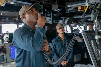 Cmdr. Richard Jimenez delivers a ship-wide announcement aboard USS Decatur (DDG 73).