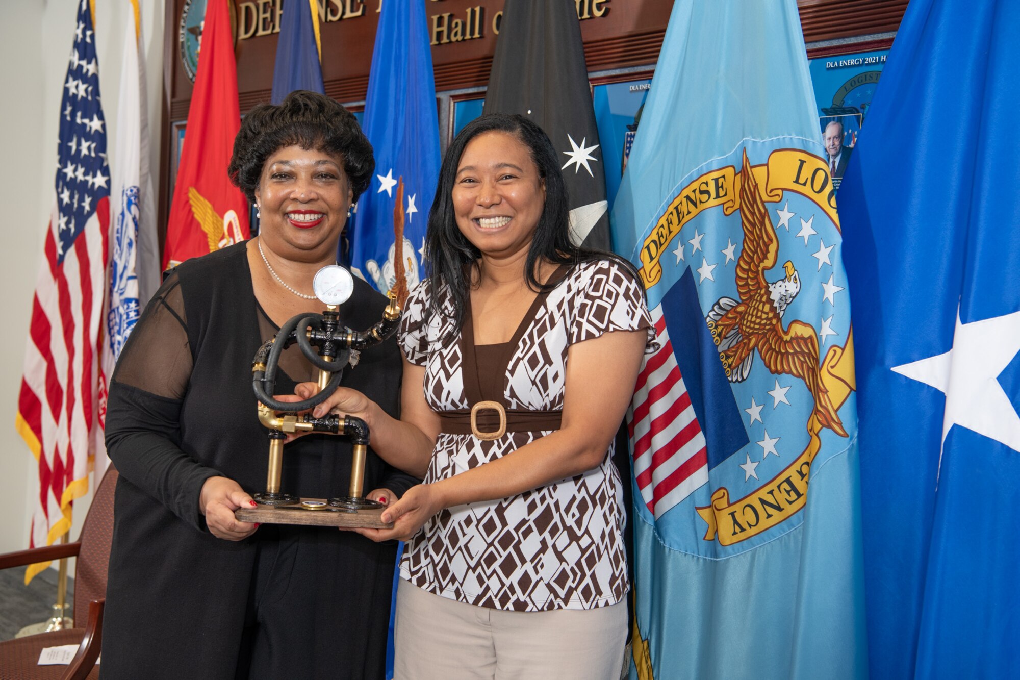 Patricia Wilkins and Regina Gray with the esteemed DLA Energy Pipeman figurine