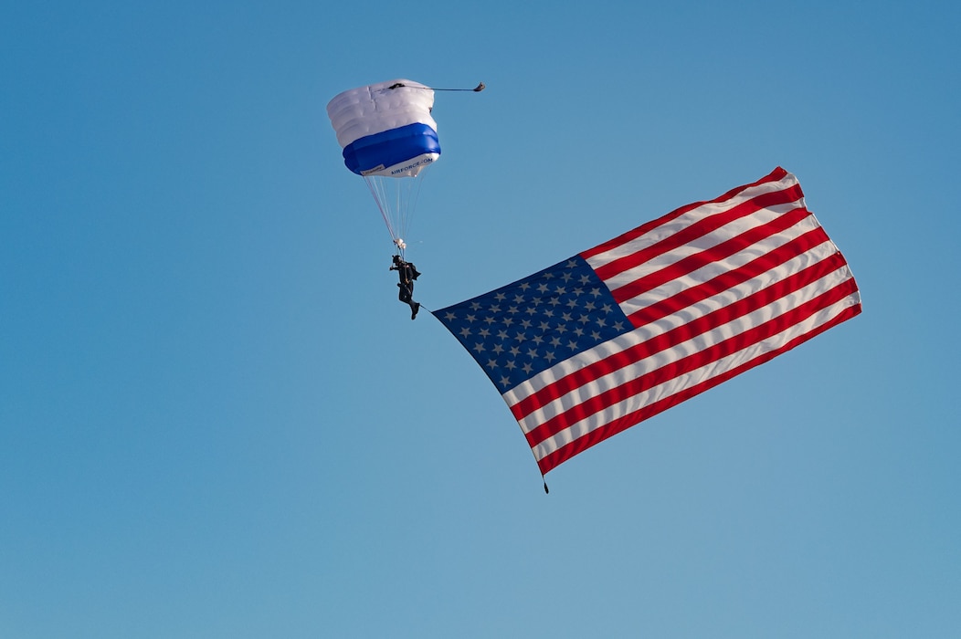 A United States Air Force Academy cadet from the Wings of Blue demonstration team displays the American flag during the Aviation Nation 2022 opening ceremony at Nellis Air Force Base, Nevada, Nov. 4, 2022. The primary mission of the Wings of Blue is to run the U.S. Air Force Academy’s Basic Freefall Parachuting course, known as Airmanship 490. (U.S. Air Force photo by Airman 1st Class Makenna Gott)