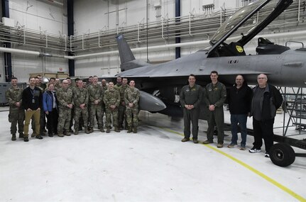 Subject matter experts from Air Combat Command, Air Force Materiel Command, the Air National Guard, Air Force Life Cycle Management Center, Air Force Reserve Test Center (AATC) and 148th Fighter Wing pose for a photo after the first AN/ASQ-236 radar was installed on an Block 50 F-16 Fighting Falcon Jan. 25, 2023.