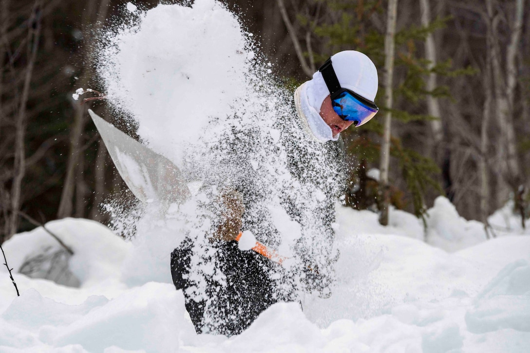 An airman shovels snow.